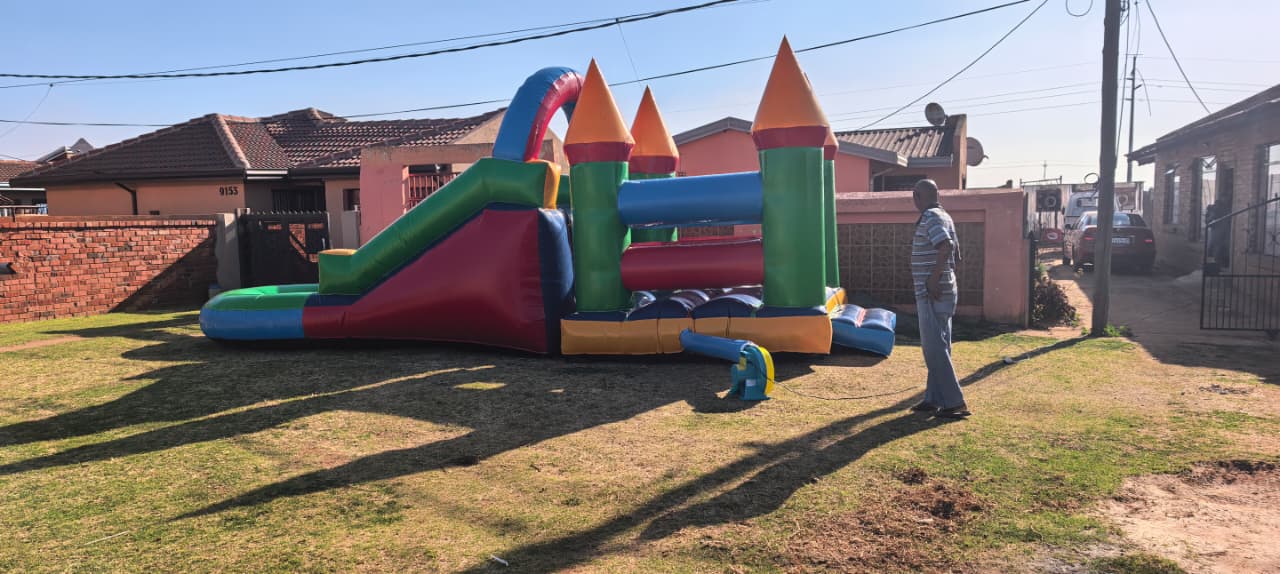 Colourful jumping castle rental with slide for children's parties